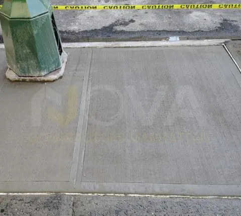 New sidewalk flags poured around the base of a green lamppost