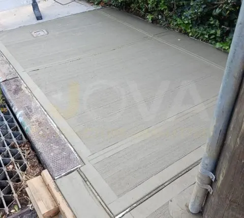New sidewalk flags beside a tree pit grate and a utility pole