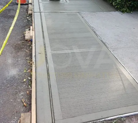 New sidewalk flags with fresh expansion joints running along the curb
